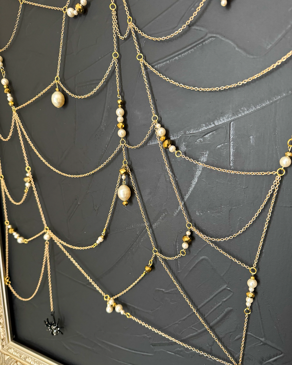 Pearl and gold bead details in the chain web of Weaver
