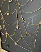 Pearl and gold bead details in the chain web of Weaver