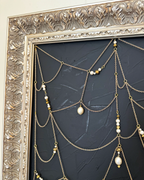 Close detail of Weaver gold chain web, pearls, beads, and ornate frame
